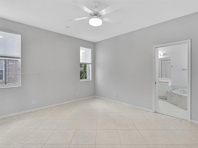 unfurnished room featuring light tile patterned flooring, ceiling fan, and a textured ceiling