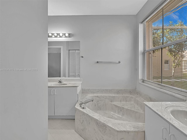 bathroom with tiled bath and vanity