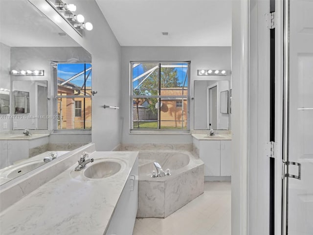 bathroom featuring tile patterned floors, tiled bath, and vanity