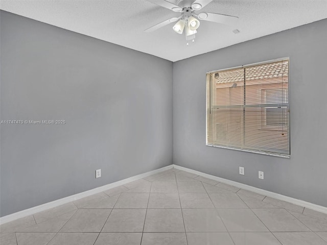 tiled spare room with a textured ceiling and ceiling fan