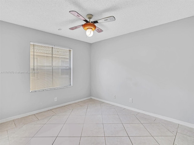 tiled spare room with a textured ceiling and ceiling fan