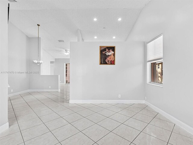 unfurnished room with ceiling fan with notable chandelier and light tile patterned floors