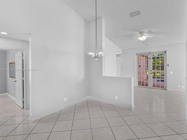 tiled spare room featuring an inviting chandelier, french doors, and a textured ceiling