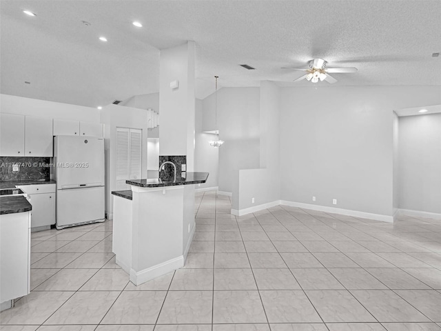 kitchen with backsplash, white cabinetry, decorative light fixtures, ceiling fan with notable chandelier, and white refrigerator