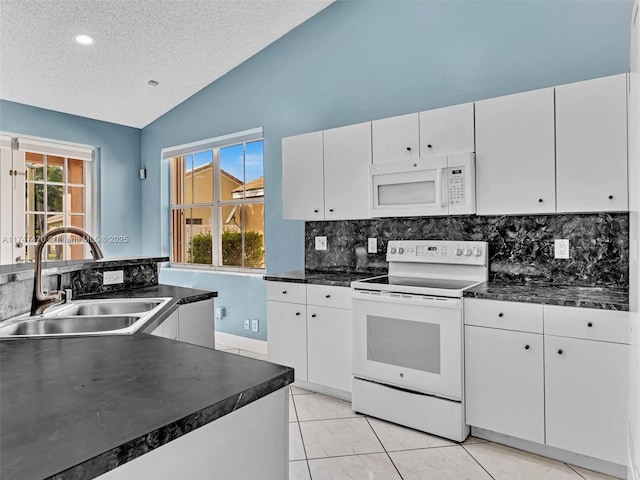 kitchen featuring white appliances, white cabinetry, sink, and lofted ceiling