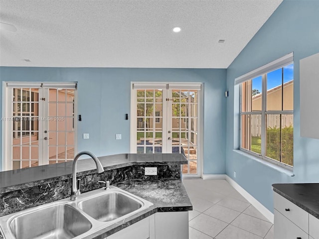 kitchen with white cabinets, french doors, sink, and a textured ceiling