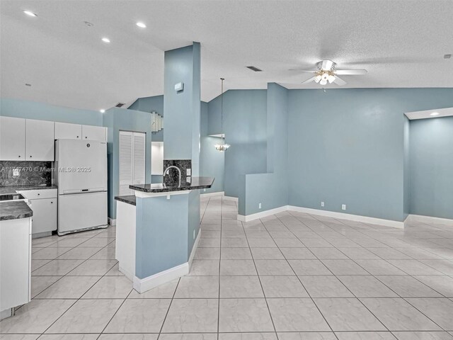 kitchen with white cabinetry, lofted ceiling, white fridge, ceiling fan, and pendant lighting