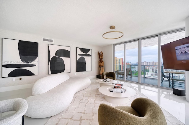 living room with expansive windows and a textured ceiling