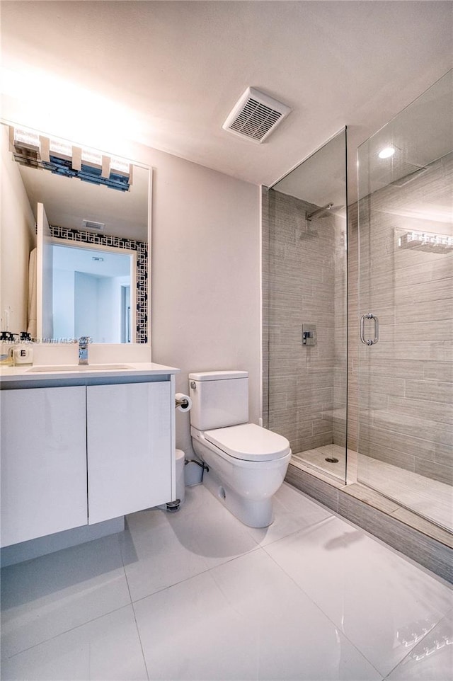 bathroom with a shower with shower door, vanity, toilet, and tile patterned flooring