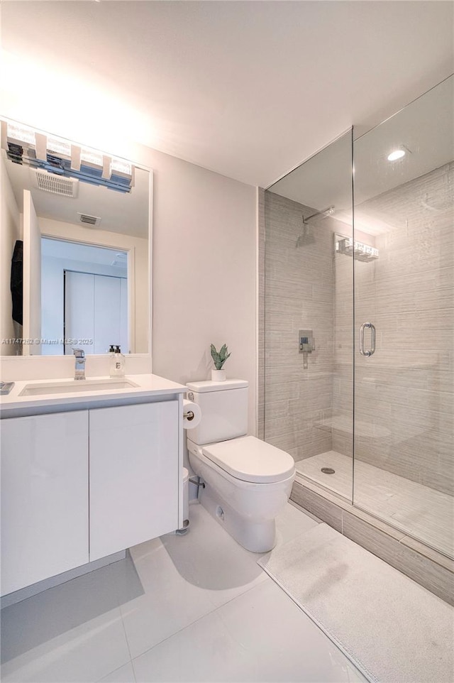 bathroom with vanity, toilet, tile patterned floors, and walk in shower