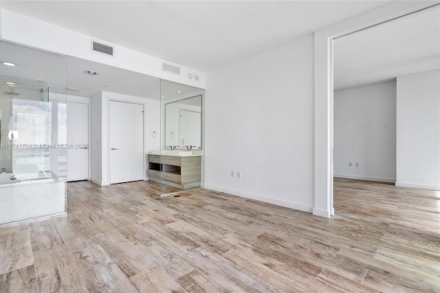 interior space featuring light hardwood / wood-style floors and ensuite bath