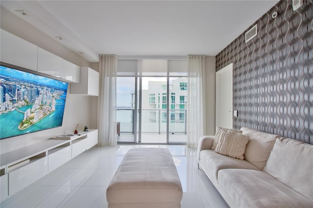 living room featuring light tile patterned floors, visible vents, and wallpapered walls