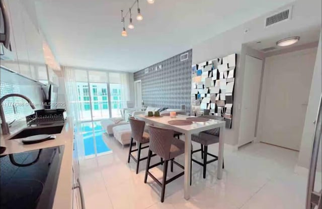 dining space featuring a wall of windows and rail lighting