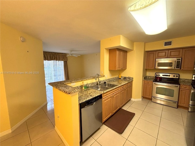 kitchen with appliances with stainless steel finishes, sink, light tile patterned floors, and kitchen peninsula