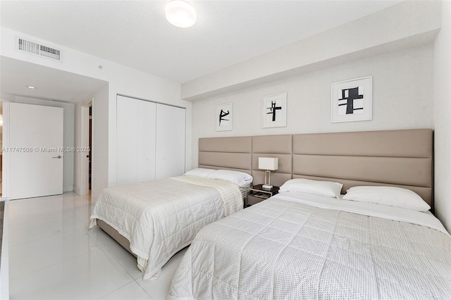 bedroom featuring visible vents, a closet, and tile patterned floors