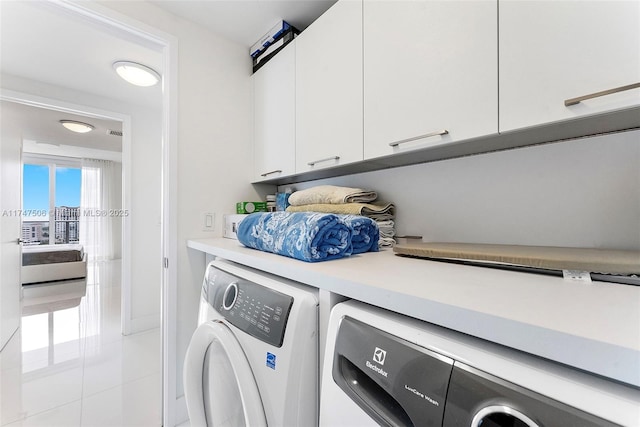 washroom with cabinet space, independent washer and dryer, and tile patterned floors