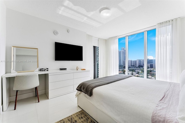 tiled bedroom with a textured ceiling and floor to ceiling windows