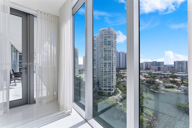 doorway featuring a city view, a water view, and tile patterned floors