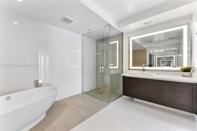 full bath featuring a freestanding tub, a stall shower, vanity, and visible vents