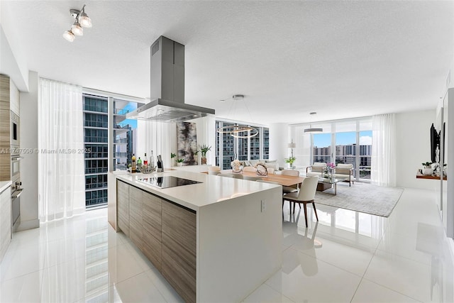 kitchen with black electric stovetop, light tile patterned floors, island range hood, and modern cabinets