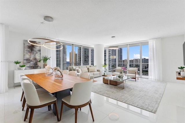 dining area featuring a textured ceiling, a wall of windows, tile patterned flooring, and a city view