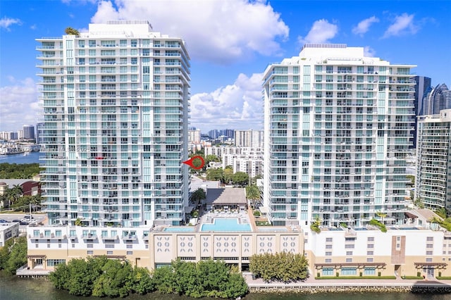 view of building exterior featuring a water view and a city view