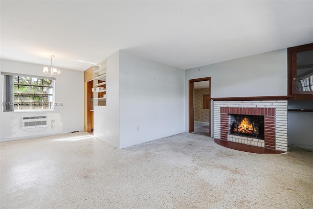 unfurnished living room featuring a chandelier, a wall unit AC, and a fireplace