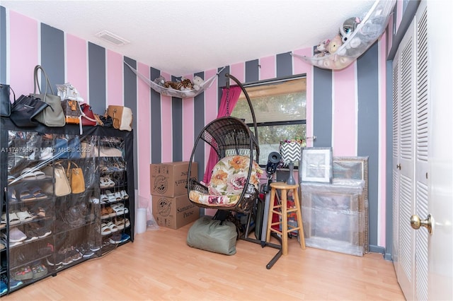 bedroom featuring a textured ceiling and wood-type flooring