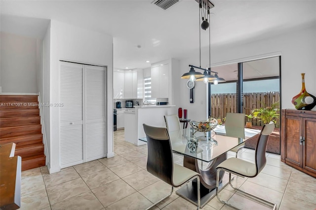 dining area featuring sink and light tile patterned flooring