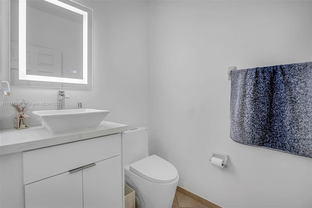 bathroom featuring vanity, tile patterned flooring, and toilet