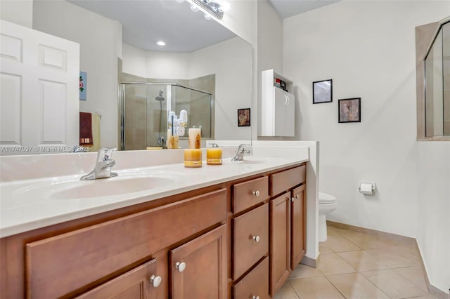 bathroom featuring toilet, vanity, tile patterned flooring, and a shower with shower door