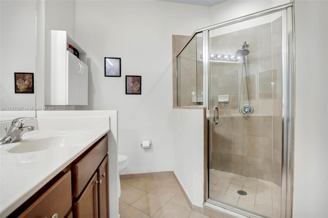 bathroom with a shower with shower door, vanity, toilet, and tile patterned floors