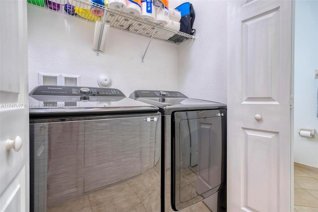 laundry room with washing machine and dryer and light tile patterned floors