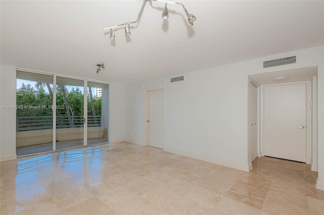 spare room with floor to ceiling windows