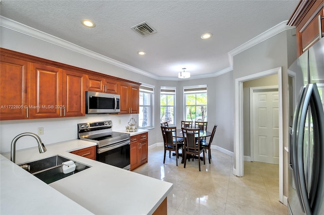 1632 NE Winterberry Ln, Weston, FL 33327 - kitchen with a sink, visible vents, light countertops, ornamental molding, and appliances with stainless steel finishes