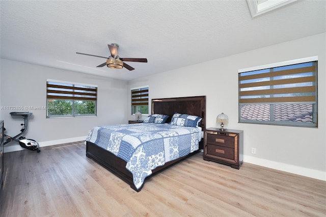 1632 NE Winterberry Ln, Weston, FL 33327 - bedroom with a textured ceiling, baseboards, a ceiling fan, and light wood-style floors