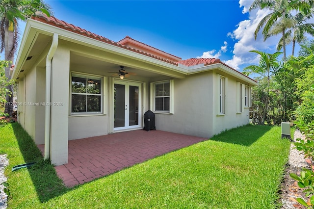 1632 NE Winterberry Ln, Weston, FL 33327 - rear view of property featuring a tile roof, a yard, a patio, stucco siding, and a ceiling fan