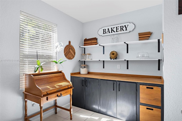 home office with light tile patterned floors and a dry bar