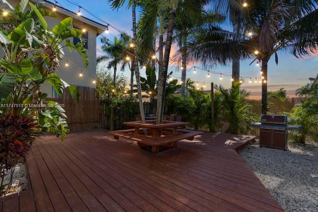 wooden deck with fence, outdoor dining area, and grilling area