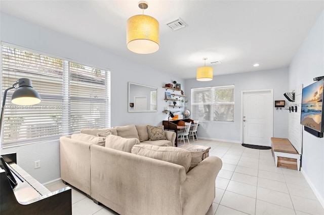 living room with baseboards, visible vents, and light tile patterned floors