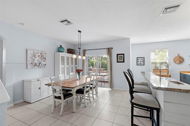 dining area featuring plenty of natural light, light tile patterned flooring, and visible vents