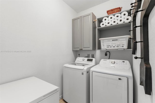 washroom featuring washing machine and clothes dryer and cabinet space