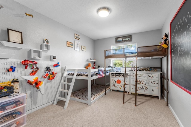 bedroom featuring baseboards, carpet floors, and a textured ceiling