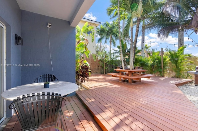 wooden terrace with outdoor dining space and fence