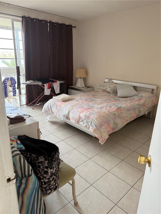 bedroom featuring light tile patterned floors and access to outside