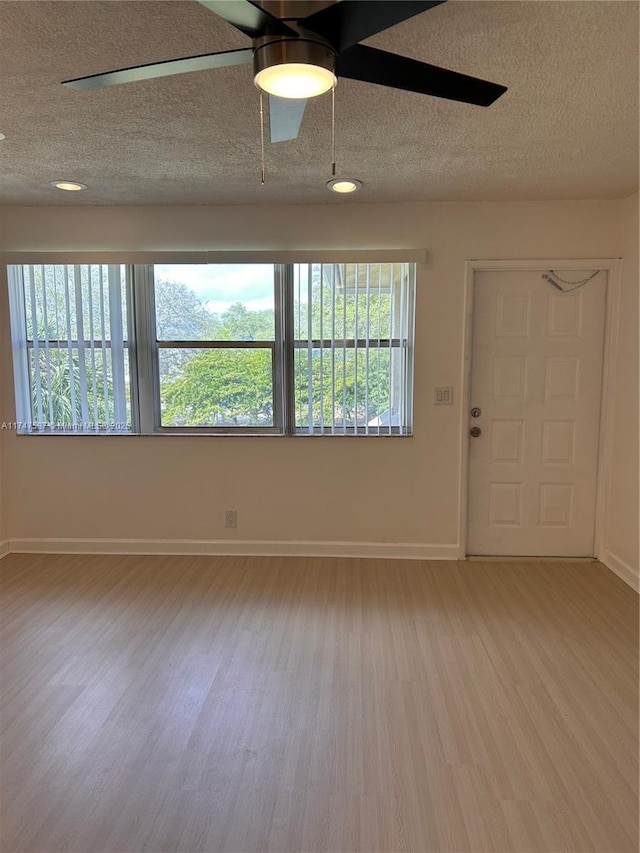 unfurnished room with a textured ceiling, ceiling fan, and wood-type flooring