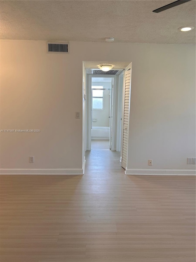 empty room featuring light hardwood / wood-style flooring and a textured ceiling