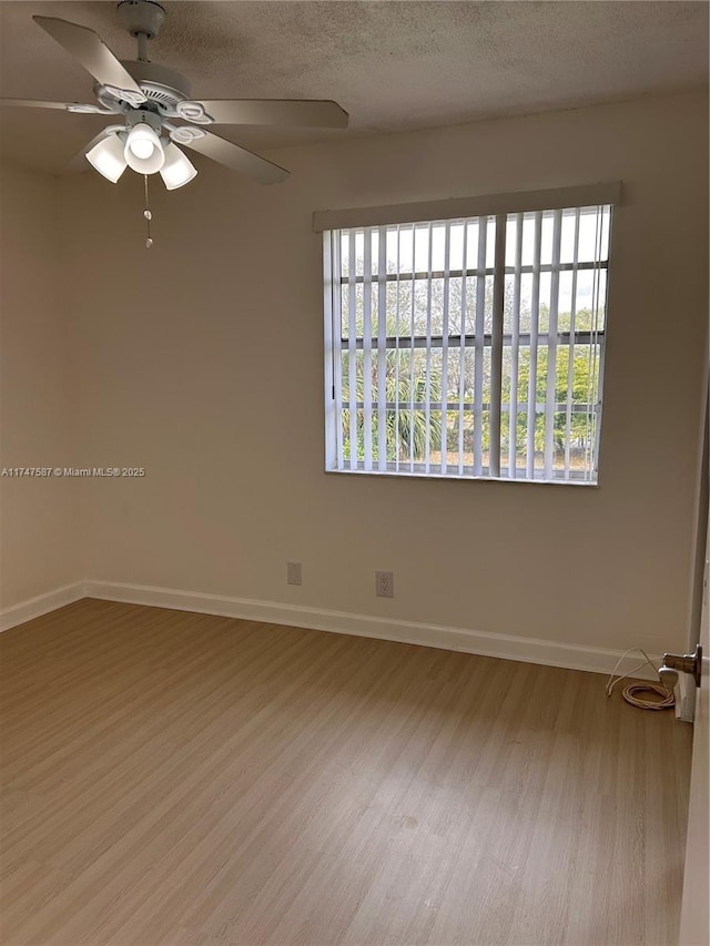 spare room with light hardwood / wood-style floors, ceiling fan, and a textured ceiling