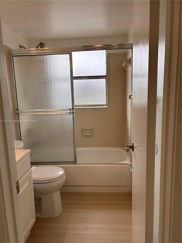 full bathroom with toilet, hardwood / wood-style flooring, vanity, and enclosed tub / shower combo