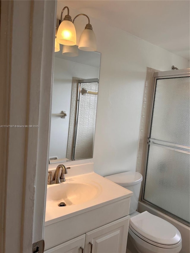 full bathroom featuring toilet, vanity, and combined bath / shower with glass door